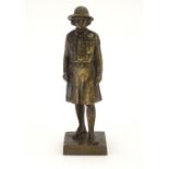 A 20thC cast bronze model of a Girl Guide wearing a hat and uniform, on a square base. Approx. 6"