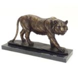 A 20thC cast bronze model of a prowling tiger, mounted on a rectangular marble base. Approx. 8 3/