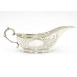 An American Mid 19thC white metal sauce boat with engraved floral and foliate decoration. Bears