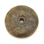A Chinese carved hardstone roundel with incised geometric detail. Approx. 2" diameter Please