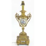 A 20thC Continental table lamp, the urn shaped body with gilt metal mounts and hand painted scene