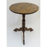 A 19thC tripod table with a rounded top above a turned pedestal base and three shaped legs. 21" in