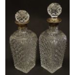 Two cut glass decanters with silver collars. Hallmarked London 1934. Approx 9" high Please Note - we
