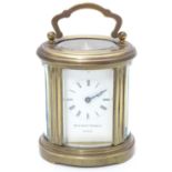 A late 20th Century small carriage clock by Matthew Norman , London. With oval brass case, the white