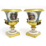 A pair of hand painted twin handled campagna urns, each decorated with a young seated couple on a