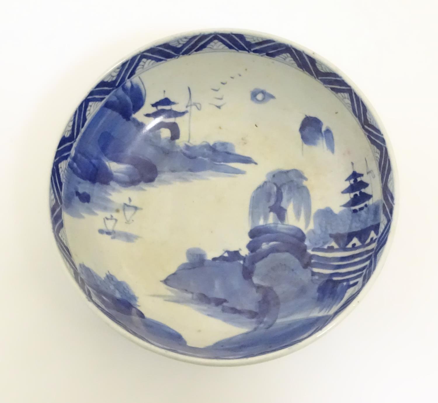 A Chinese blue and white bowl with hand painted decoration depicting an Oriental landscape with - Image 3 of 10