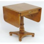 A late 20thC elm table with drop flaps above a single short drawer with brass handles and brass back