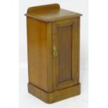 A late 19thC / early 20thC mahogany bedside cabinet / pot cupboard with a shaped upstand above a