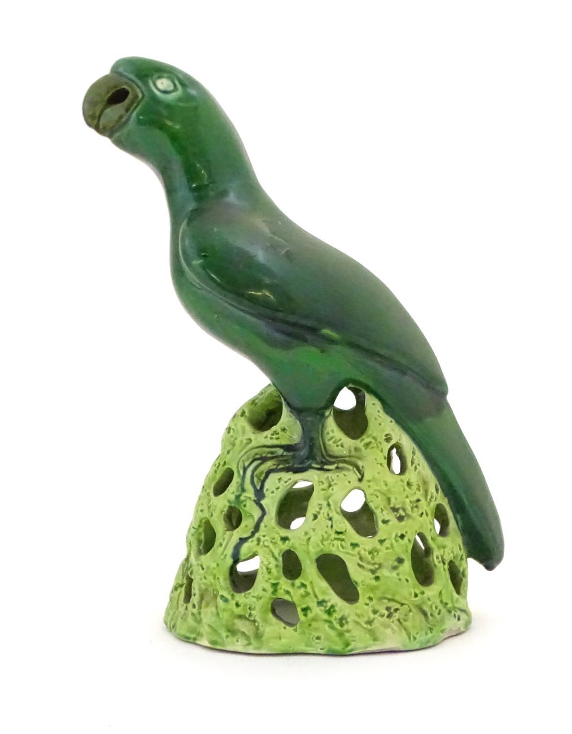 A Chinese model of a parrot with a green glazed on a pierced base. Approx. 12" high Please Note - we