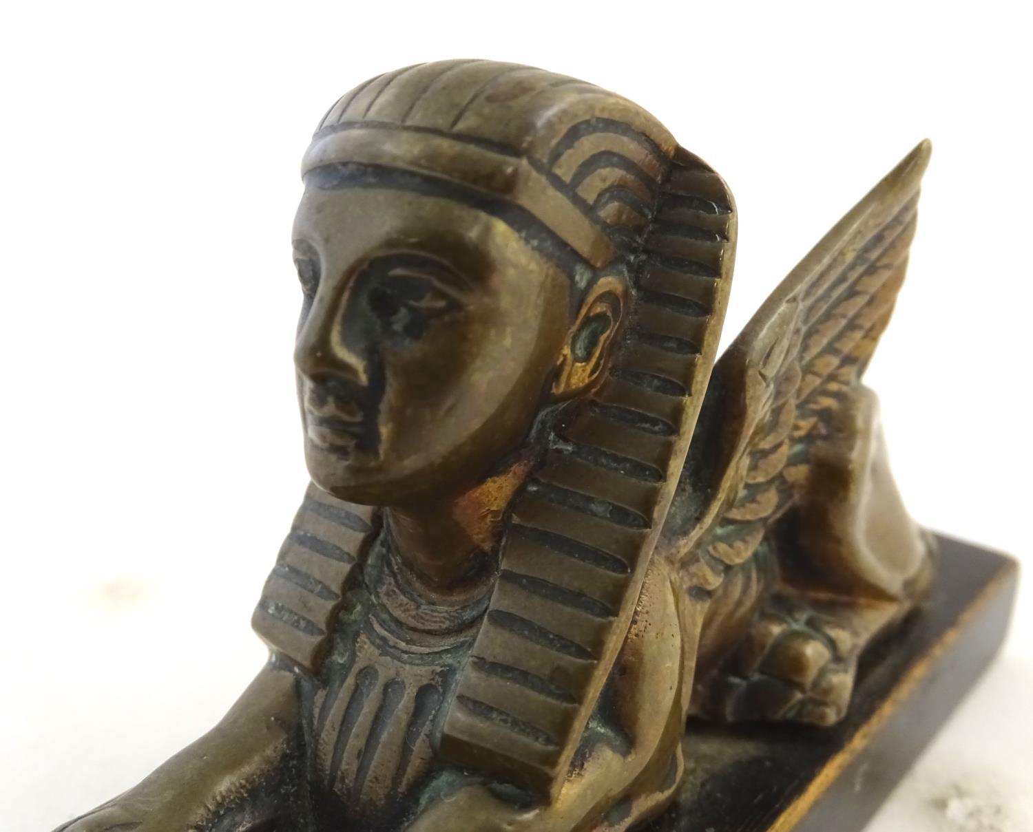 A 20thC paperweight formed as a winged sphinx with the head of a pharaoh on a rectangular wooden - Image 7 of 7