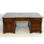 A late 20thC mahogany double pedestal partners desk of large proportions, having a gold tooled