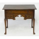 A mid 18thc oak lowboy with a moulded rectangular top above a single long and two short drawers with