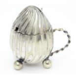 A silver plate mustard pot with hinged lid loop handle and three ball feet. 3" long Please Note - we