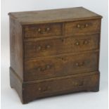 An oak Georgian chest of drawers comprising two short over three long drawers with brass swan neck