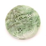 An Oriental jade roundel carving depicting a stylised dragon. Approx. 2 1/4" diameter Please
