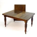 An early 20thC walnut dining table with an additional leaf. Having a table with a moulded top and