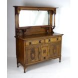 A late 19thC oak Art Nouveau dresser with a moulded cornice above a large mirrored back with twin