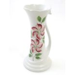 An E Radford hand painted jug / vase with a tendril formed handle and hand painted clematis flower