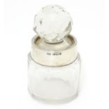 A cut glass scent/salts bottle with stopper and silver collar. Hallmarked Birmingham 1912 maker