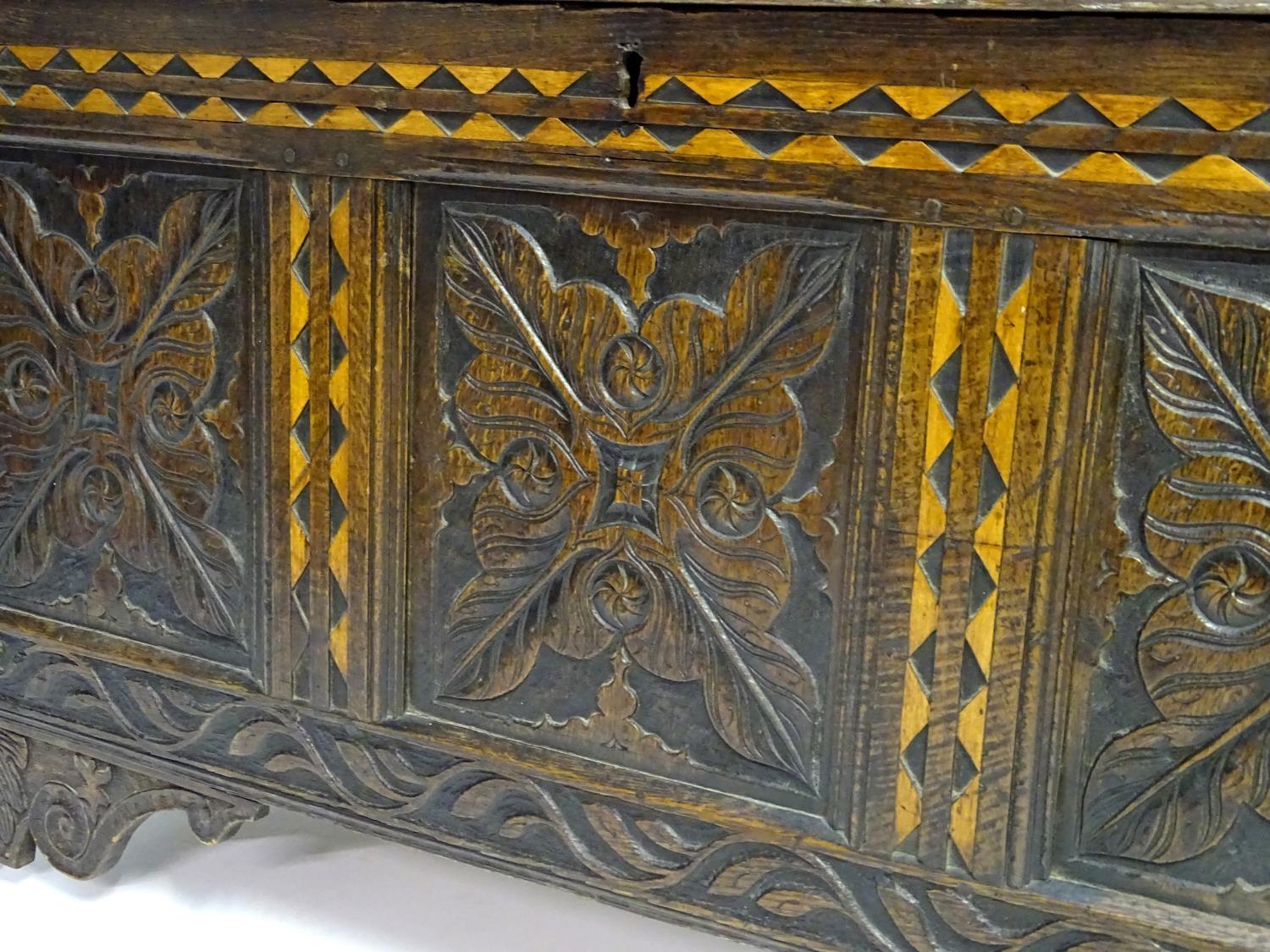 A 17thC oak three panel coffer with a moulded lid above carved panelling to the front with floral - Bild 8 aus 11