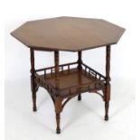 An Aesthetic movement walnut table with an octagonal top above a galleried under tier with corner