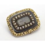 Mourning / Memorial jewellery : A 19thC yellow metal memorial brooch, the central glazed panel