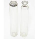 Two glass dressing table bottles with silver tops hallmarked London 1895. The tallest 7" high Please
