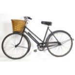 A mid-20thC Raleigh ladies' bicycle, fitted with a wicker pannier basket, approximately 75" long