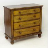 An early 19thC mahogany chest of drawers with a crossbanded inverted breakfront top above a carved