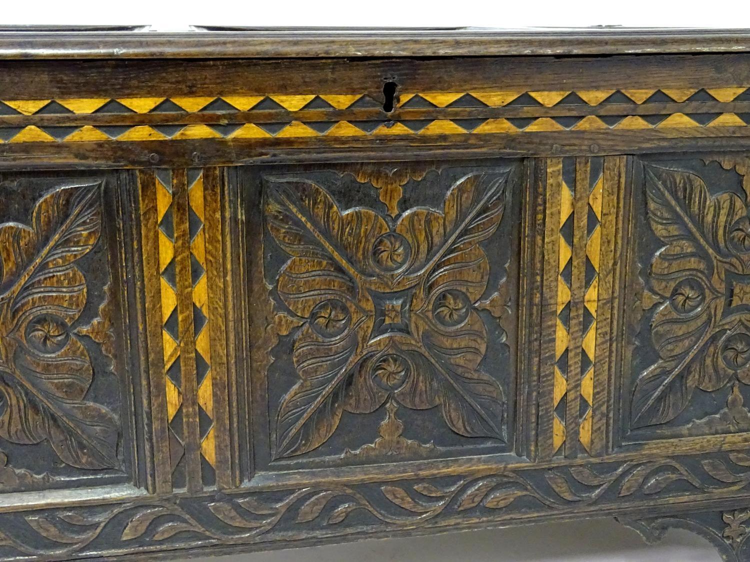 A 17thC oak three panel coffer with a moulded lid above carved panelling to the front with floral - Bild 10 aus 11
