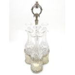 A Victorian silver plate tantalus / bottle stand with three cut glass decanters. The whole approx