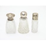 3 various cut glass perfume / scent bottles with silver tops. The tallest 3 1/2" high Please
