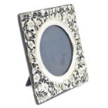 A photograph frame with Art Nouveau silver surround with floral and foliate detail. hallmarked
