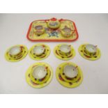 Toys: A mid 20thC Chad Valley tinplate tea set in bright yellow decorated with sprays of flowers and