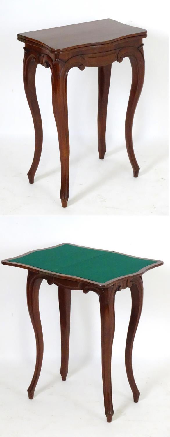 A small 19thC mahogany card table with a serpentine shaped rotating top opening to show baize