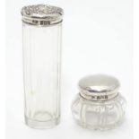 Two cut glass dressing table pottles with silver tops. One hallmarked Birmingham 1909 maker Levi &