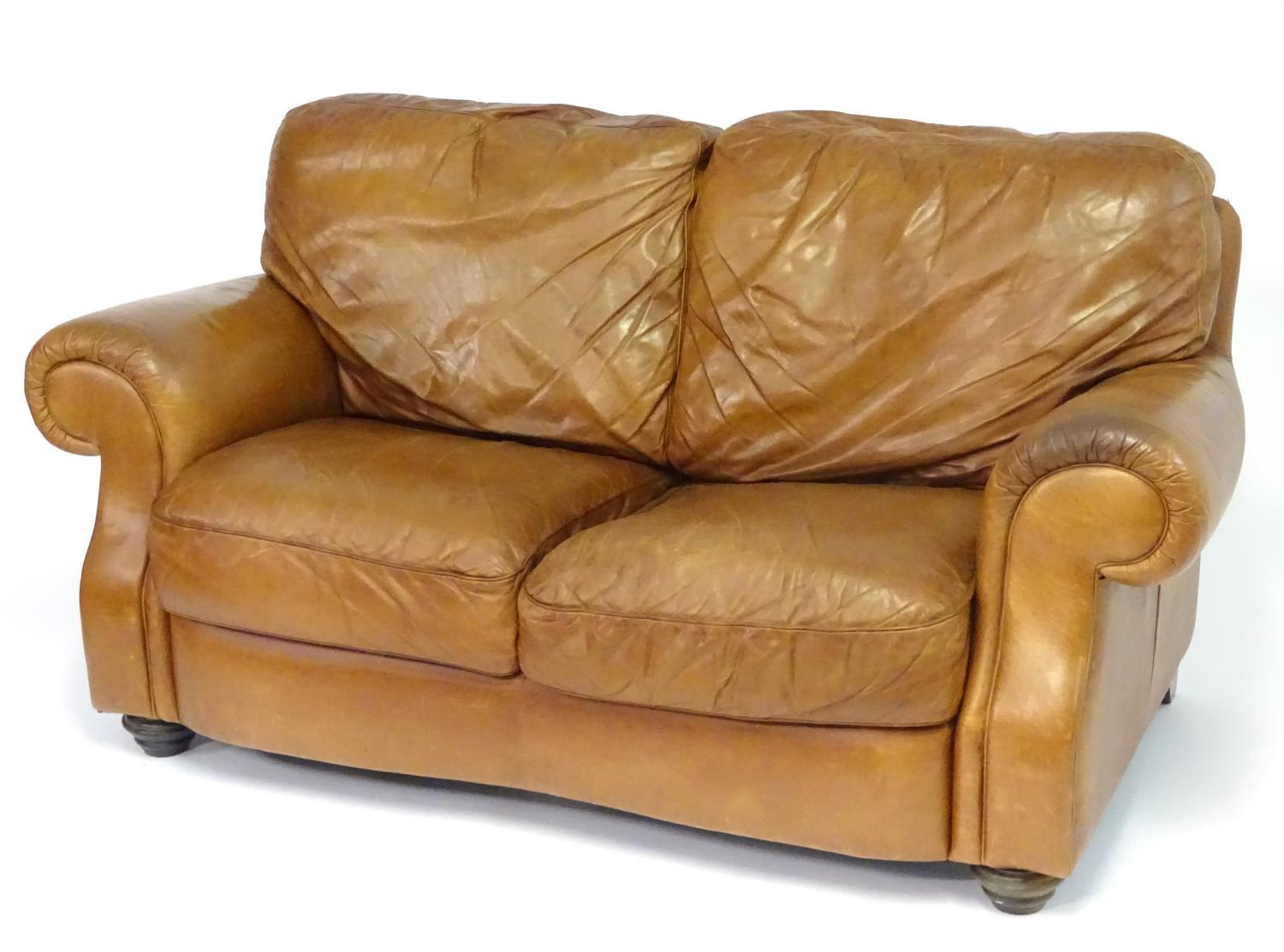 A late 20thC Italian tan leather two-seat sofa, 67" wide, 31" deep, 40" tall Please Note - we do not