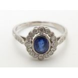 An 18ct white gold ring set with central sapphire bordered by diamonds Please Note - we do not