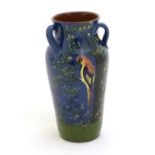 A Longpark Torquay tyg vase with relief parrot decoration and hand painted landscape decoration with