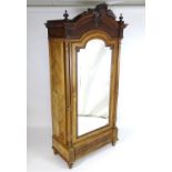 A late 19thC rosewood armoire with a shaped carved pediment flanked by turned finials and having a