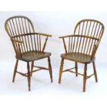 Two early 19thC elm and ash double bow back Windsor chairs, with turned spindle supports above