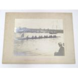 An early 20thC monochrome photograph depicting a rowing Regatta, a passing racing boat with crew