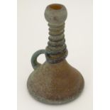 An amber glass jug with loop handle and coiled decoration to neck, with oxidised finish. In the