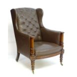 A mid 19thC wingback leather armchair with a deep buttoned backrest, two turned supports above