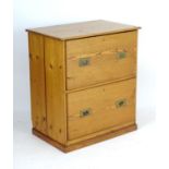An early 20thC pine two drawer chest with campaign style handles. 33" wide x 22" deep x 37" high.