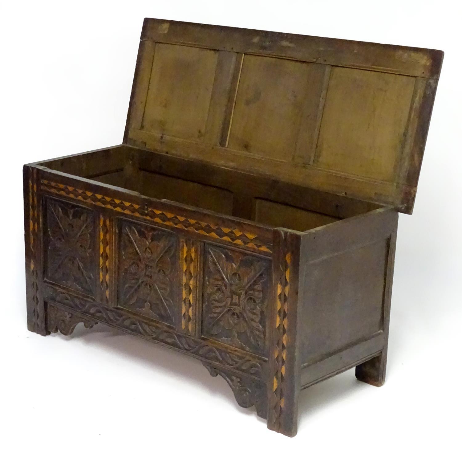 A 17thC oak three panel coffer with a moulded lid above carved panelling to the front with floral - Bild 6 aus 11