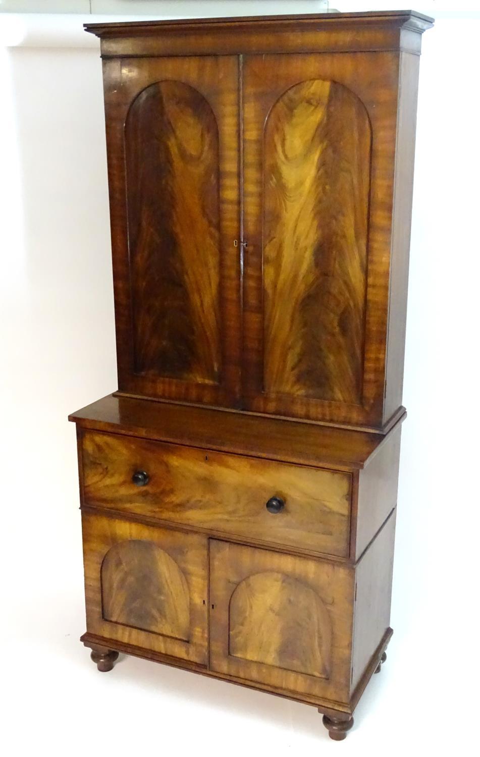 A mid 19thC mahogany secretaire bookcase, having a moulded cornice above two flame mahogany panelled