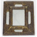 A 20thC mirror with an embossed frame. 11" wide x 13" high. Please Note - we do not make reference