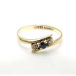 A 9ct gold ring set with central spinel flanked by two white stones. Ring size approx J 1/2 Please
