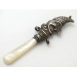 A child's rattle with mother of pearl teether and silver Mr Punch decoration. Hallmarked